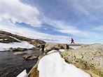 Spain, Sierra de Gredos, hiker crossing brook in mountains stock photo