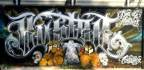 Graffiti On The Side Of A Building With Skulls And Pumpkins In Front Of It