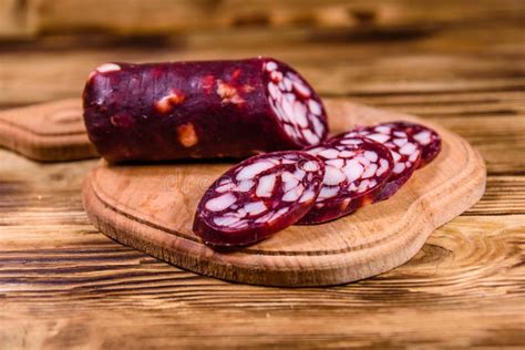 Cutting Board With Sliced Salami Sausage On A Wooden Table Stock Image