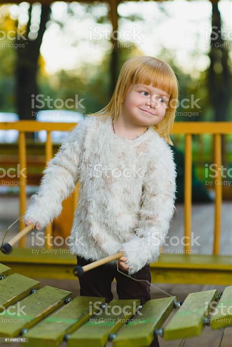 Close Up Portrait Of Cute Girl Playing Xylophone Outdoor Stock Photo