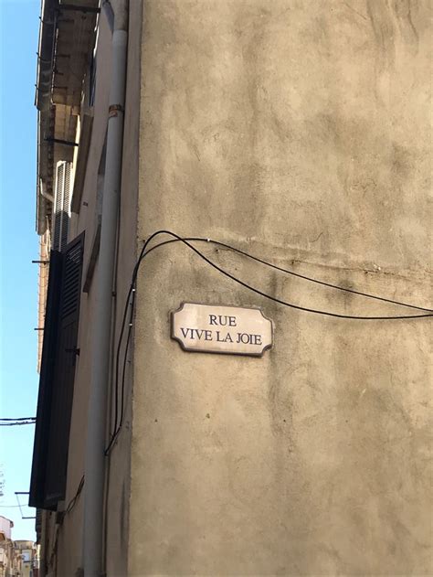 A Street Sign Attached To The Side Of A Building In An Alleyway With