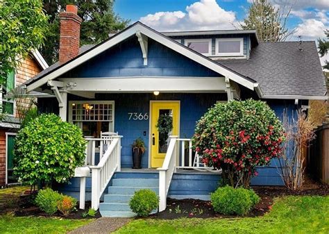 A Blue House With Yellow Door And Steps Leading Up To The Front Porch