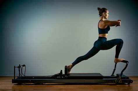 Premium Photo Young Woman Doing Pilates Exercises With A Reformer Bed
