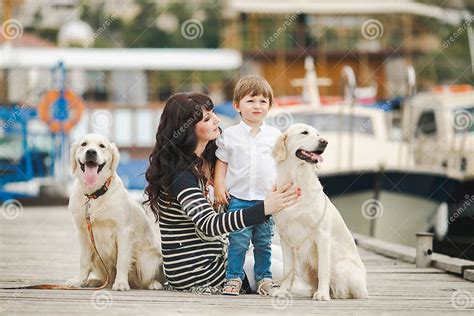 Mother And Son With A Dog Sitting On The Waterfront Stock Image Image