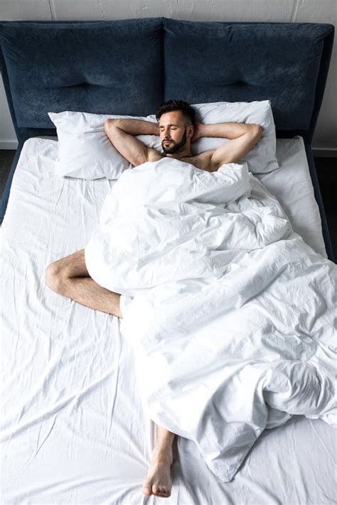 Handsome Shirtless Bearded Man Sleeping In Bed Under White Blanket