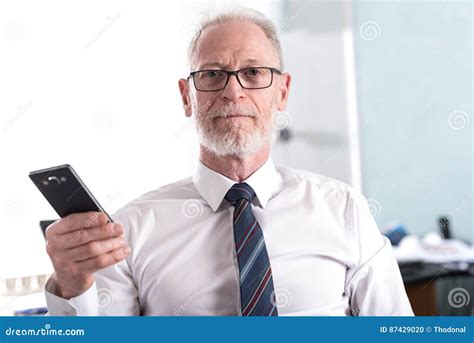 Portrait Of Senior Businessman Holding His Mobile Phone Stock Photo