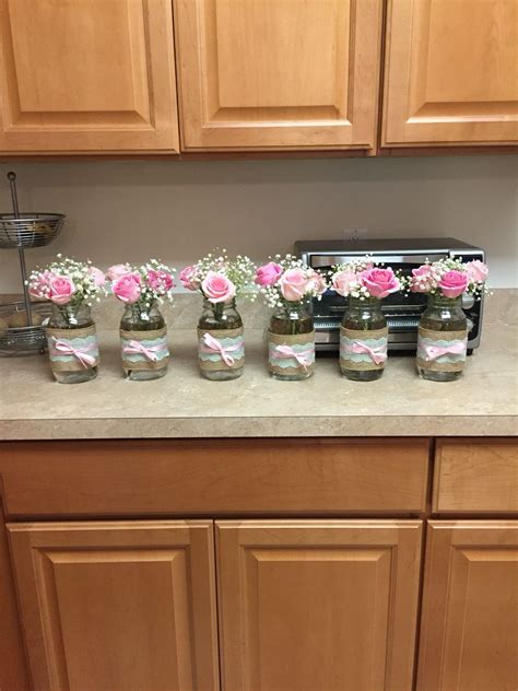 A Kitchen Counter Topped With Jars Filled With Flowers