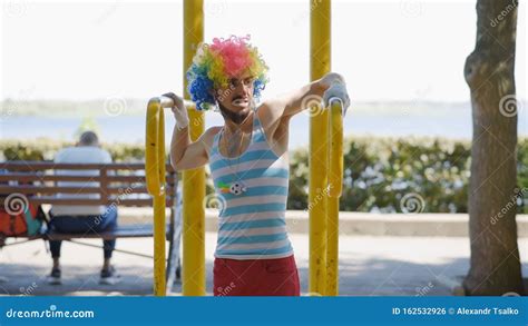 Mime Pulls Up On The Uneven Bars In The Park The Clown Shows The