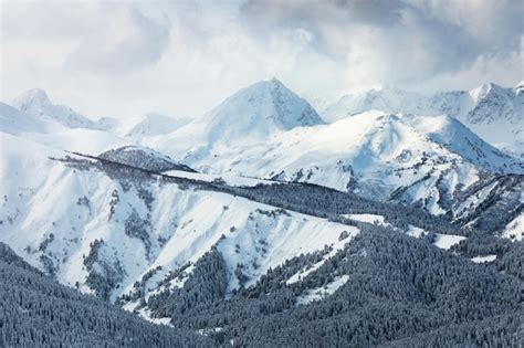 Premium Photo Snow Covered Mountain Peaks In The Clouds