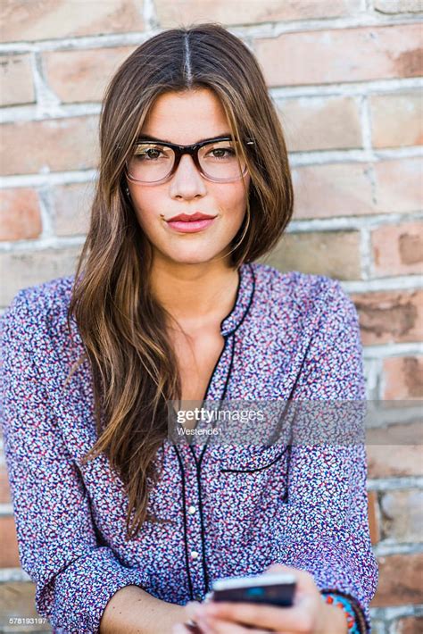Portrait Of A Brunette Young Woman With Glasses Outdoors High Res Stock