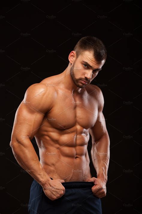 Strong Athletic Man Fitness Model Showing Torso With Six Pack Abs Stands Straight And Puts