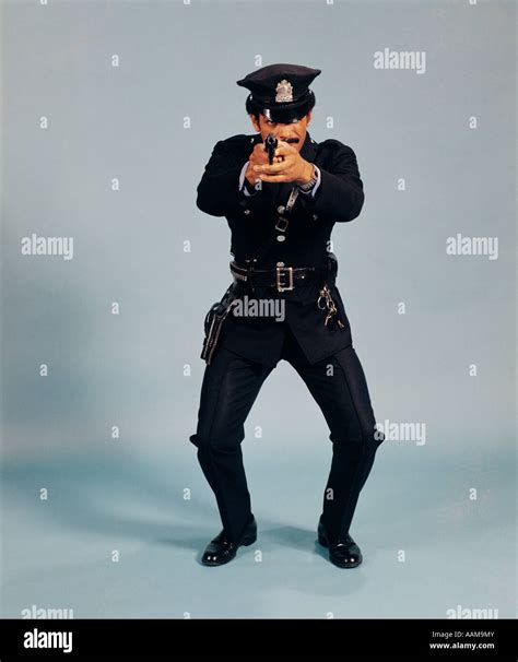 1970s Full Length Police Officer Man Pointing Gun At Camera Action