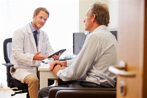 Male Patient Having Consultation With Doctor In Office Stock Image