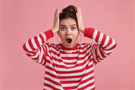 Free Photo Indoor Shot Of Shocked Stunned Young Woman Keeps Mouth