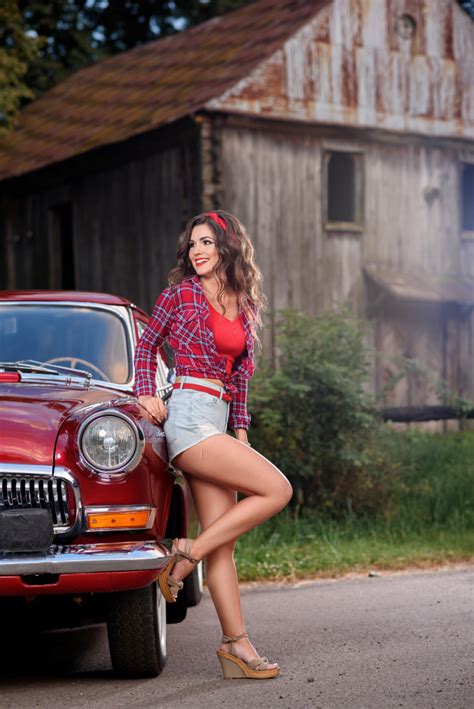 Pin Up Girl Posing Near Red Vintage Car In The Countryside