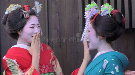 geisha in a red dress lifts up a fan and covers half of the face stock footage video of cute