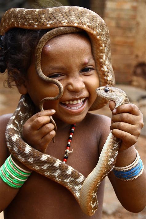 A Girl From A Snake Charmer Community Plays With Snakes On World Snake