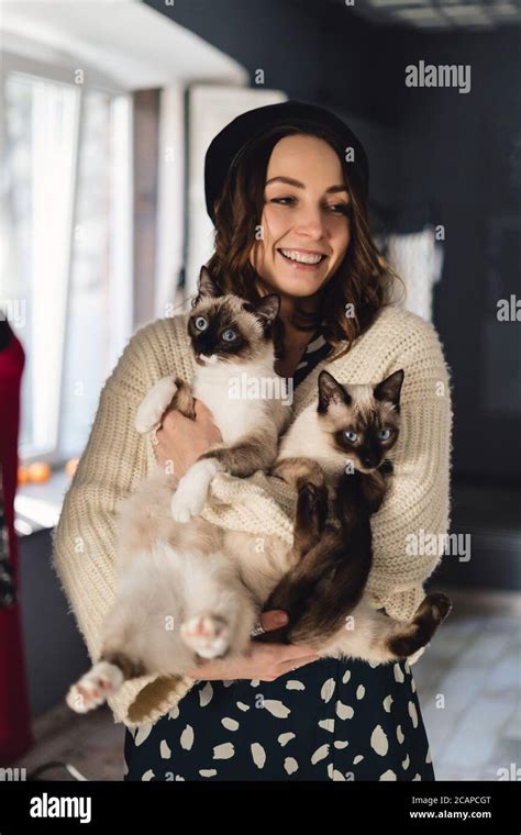 Attractive Girl Embracing Her Siamese Cats Indoor Portrait Of Cute
