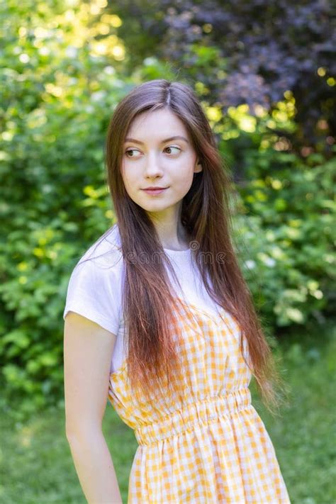 A Beautiful Brunette Girl Stands In The Shade Of A Garden On A Hot Day Stock Image Image Of