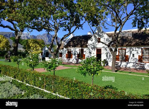 Dutch Style House On The Main Street In Franschhoek With A Statue Of