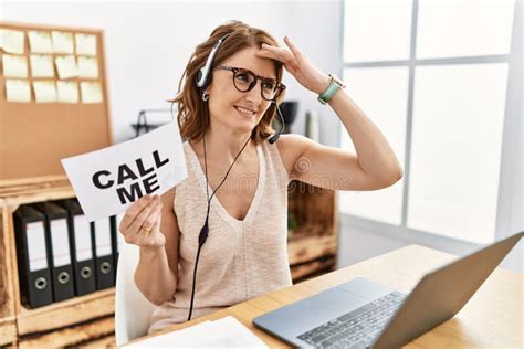 Middle Age Brunette Woman Wearing Operator Headset Holding Call Me Banner Smiling Confident