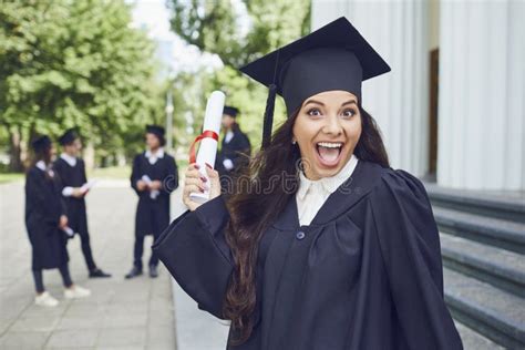 Graduate Girl Smiling Against The Background Of A Group Of Graduates