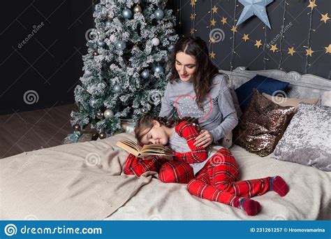 Maman Et Fille En Pyjama Lumineux S Amusent Sur Le Lit Devant L Arbre De No L Image Stock