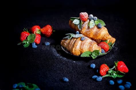 Croissants And Berries Sprinkled With Powdered Sugar Stock Photo