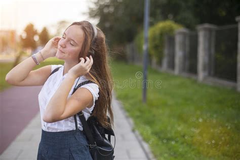 Young Cute Girl Enjoying Music With Headphones Outdoors Stock Image