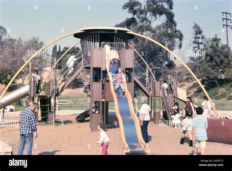 Kids Having Fun On A Playground Playing On A Jungle Gym And Slide Ca