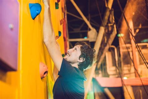 Man Climber On Artificial Climbing Wall In Bouldering Gym Stock Image