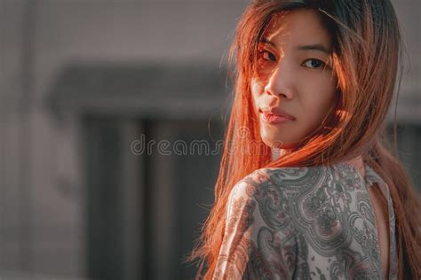 asian woman with tanned beauty skin portrait in a green garden with sun light for beauty and