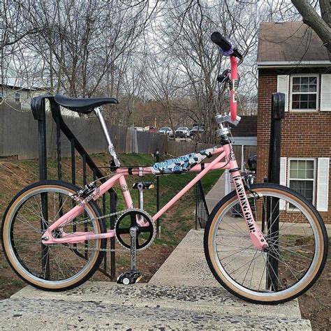A Pink And Black Bike Parked On The Side Of A Sidewalk Next To A House