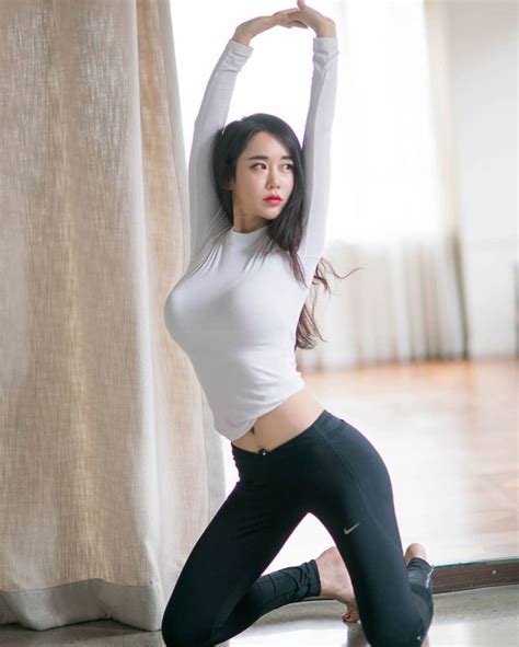 A Woman In Black Pants And White Shirt Doing Yoga