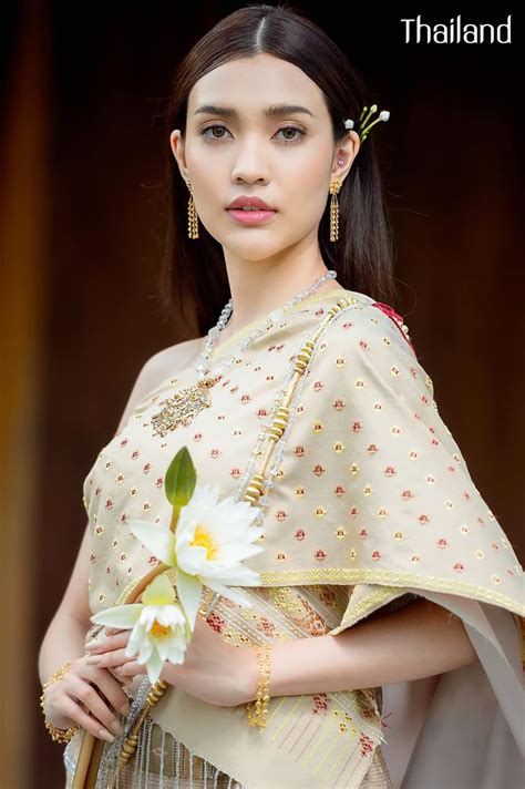A Woman In Traditional Thai Garb Holding A Flower