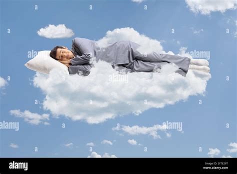 Man In Pajamas Sleeping On A Cloud And Floating In The Sky Stock Photo