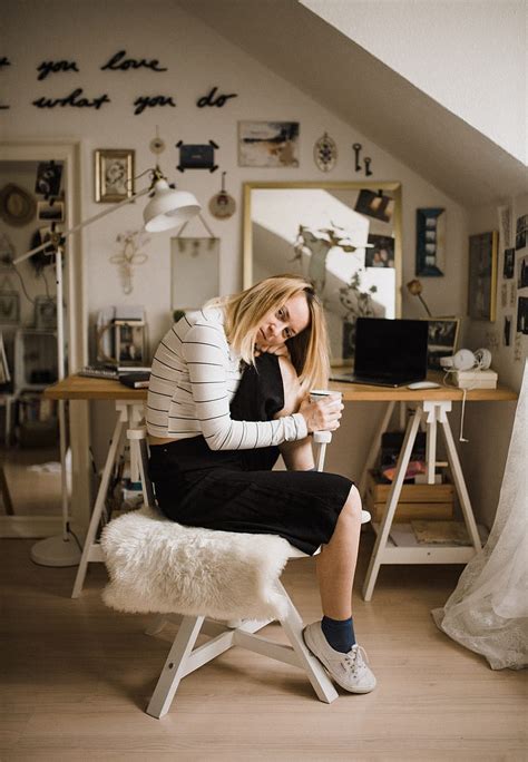 Woman Sitting On Stool Resting Her Head On Her Knee Inside Room HD