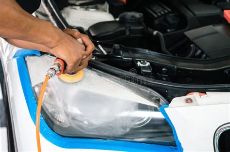 Car Headlights Cleaning With Power Buffer Machine At Car Service Stock