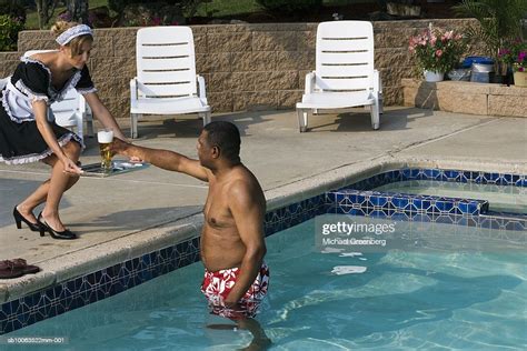 Maid Serving Beer To Mature Man Standing In Swimming Pool Photo Getty