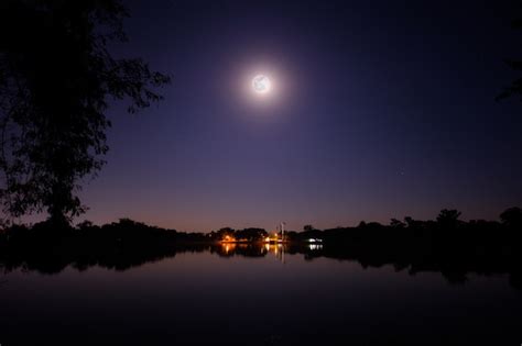 La Luna Llena Brilla En La Noche Sobre El Gran Lago Y El Pequeño Pueblo