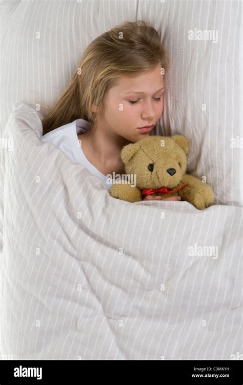 Girl Sleeping On Bed With Teddy Bear Stock Photo Alamy