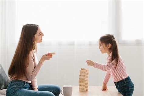 Premium Photo Mom And Daughter Play A Board Game In The Living Room
