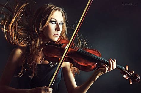 A Woman Holding A Violin In Her Right Hand