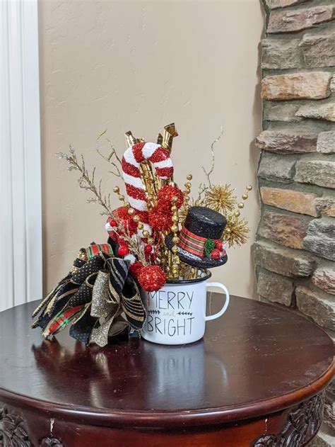 A Coffee Cup Filled With Christmas Decorations On Top Of A Table