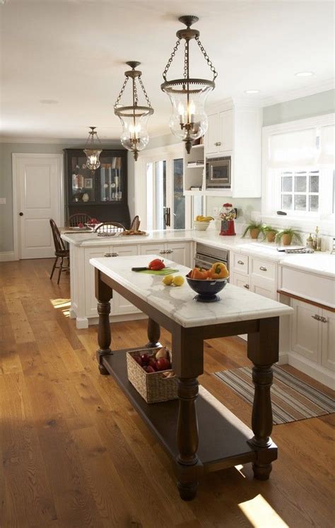 White kitchen with a large and long center island with a marble countertop. Pleasing Console Table with Marble Top Wall Decor | Kitchen remodel small, Narrow kitchen island ...