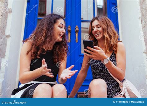 Two Best Female Friends Chatting While Using Smartphone In City Happy