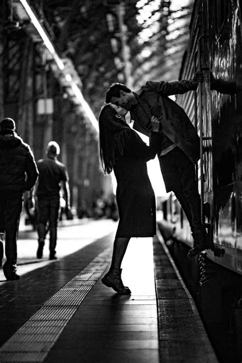 Black And White Photograph Of A Man Kissing A Woman On The Side Of A Train