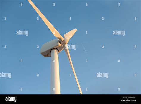 Electric Wind Turbines Farm Over Blue Sky With Wake Plane Spain Stock