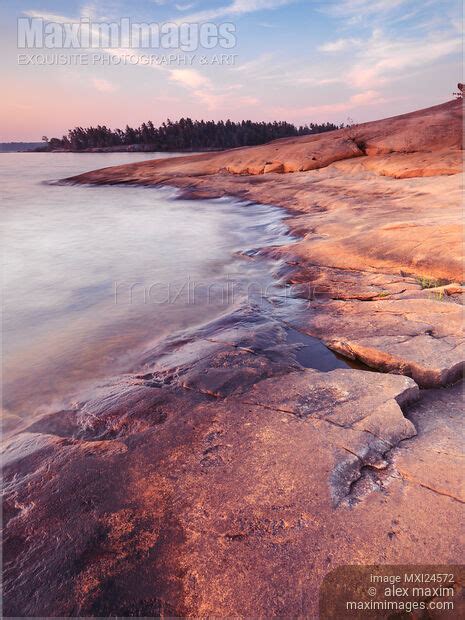 Photo Of Red Rocks On A Lake Shore At Dawn Stock Image Mxi24572
