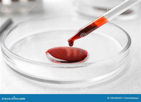 Dripping Blood From Pipette Into Petri Dish On Table Laboratory